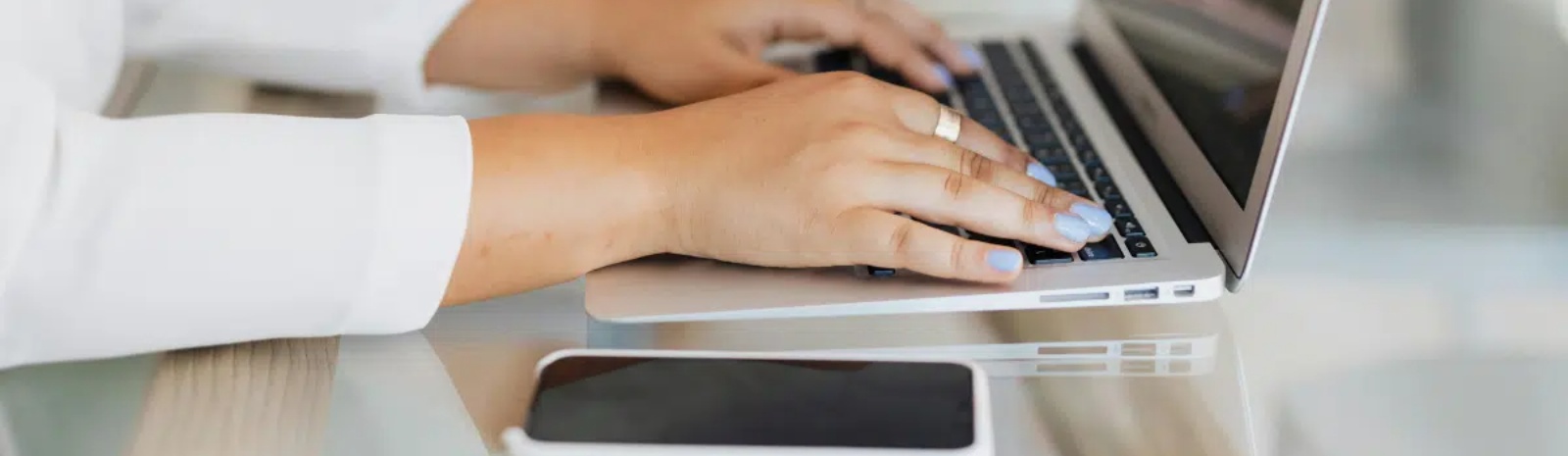 a person using their mobile phone and laptop computer