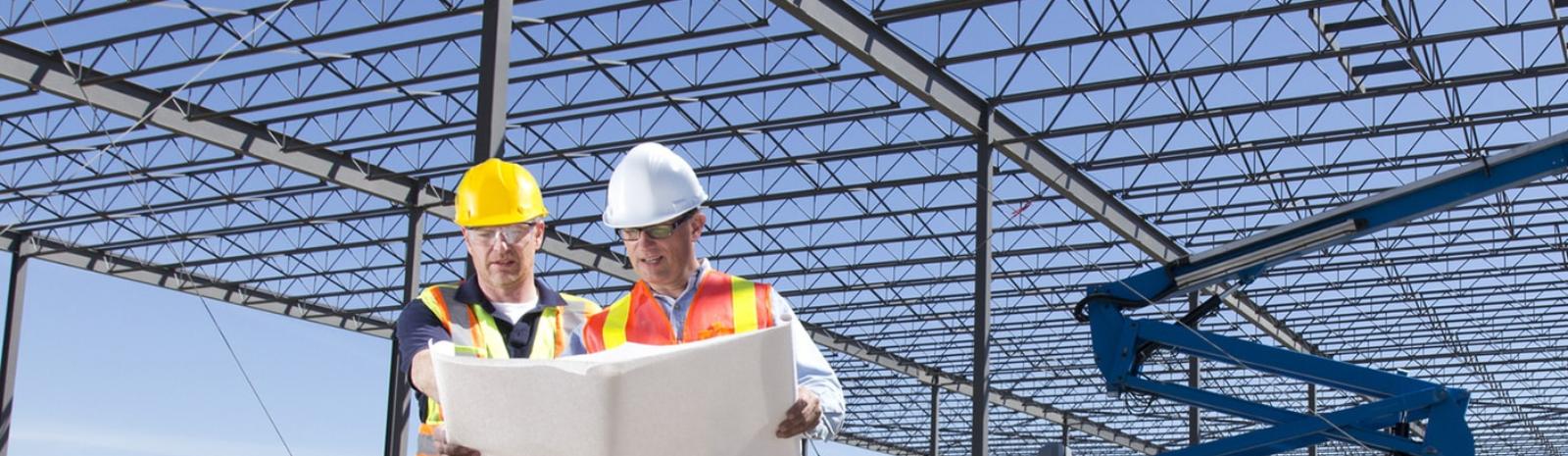 two construction workers reviewing blueprints